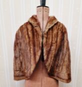 A vintage musquash fur cape, a grey possibly marten fur coat labelled 