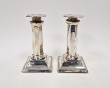 Pair Edwardian silver candlesticks, each octagonal and panelled on square bevelled foot, 15cm high,