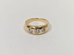 Gold and three-stone diamond ring set graduated stones in rubover setting, 6g gross (the diamonds
