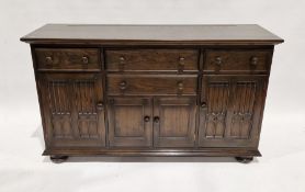 Ercol oak dresser base having a combination of four drawers and three cupboards, the cupboard