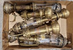 Four brass GWR wall-mounted oil lamps, three are single lights with glass chimneys and finials and