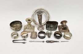 Four silver napkin rings, a pair of silver sugar tongs, silver mounted circular photograph frame and