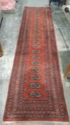 Eastern style red ground runner with one row of 18 elephant foot guls, multiple geometric borders,