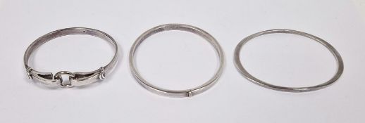 Silver bangle with ring and hook clasp, another flattened oval and another silver bangle, all marked