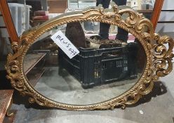 20th century gilt framed wall mirror of oval form with carved and pierced scrolling decoration, 71cm