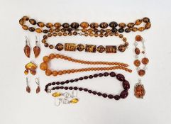 Short string of red amber coloured graduated oval beads, another string of yellow-coloured amber