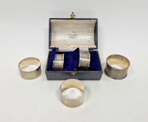 Cased pair of George V silver D shaped napkin rings, with engine turned decoration throughout,