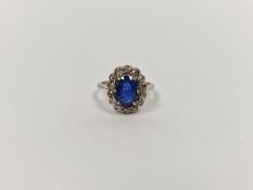 18ct white gold, sapphire and diamond cluster ring, the oval sapphire 2.3ct approx., the diamonds