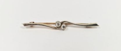 Gold-coloured metal and diamond bar brooch, the two collet-set stones within central scroll, each