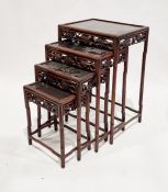 Early 20th century Chinese hardwood nest of four side tables with panelled tops and carved and