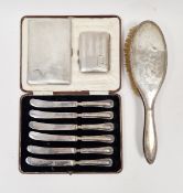 Set of six silver-handled tea knives, a silver cigarette case, engine-turned, another smaller and