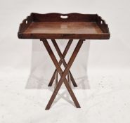 19th century mahogany butler's tray on later folding stand, the shaped gallery with pierced oval