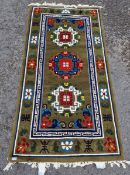 Contemporary Chinese superwash green ground rug, with three circular foliate medallions with key-