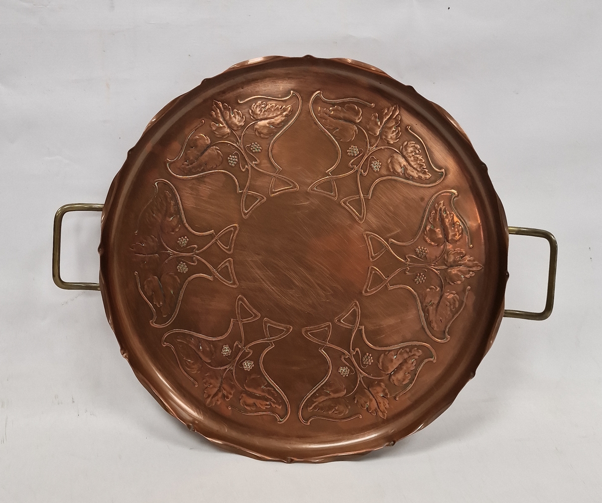 J.S & S Art Nouveau copper two-handled circular tray, cast with fruiting vine and whiplash motifs,
