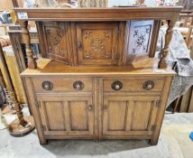 Reproduction oak court cupboard, the top section having a single door cupboard, raised over two