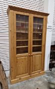 20th century pine display bookcase with two part-glazed cupboard doors opening to reveal