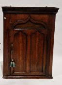 Georgian oak hanging corner cabinet, the single door opening to reveal two fitted shelves, 84cm high
