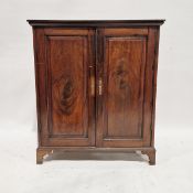 Georgian mahogany two-door storage cupboard having ornate brass escutcheons, the two doors opening