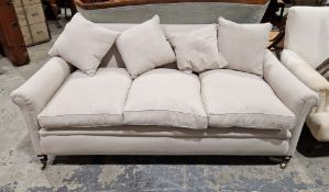 A contemporary grey upholstered three-seater sofa with four additional cushions, raised on metal