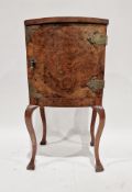 An early to mid twentieth century burr walnut bedside cupboard, the single door opening to reveal