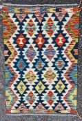 Chobi kilim, woven with geometric lozenges in red, blue, ochre, manganese against a cream ground,