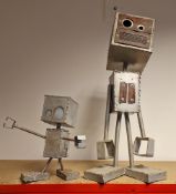 Two scrap built model robots, one with light up eyes