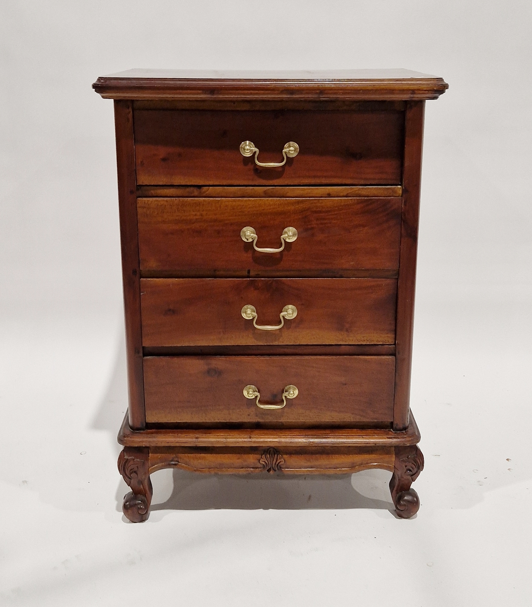 Reproduction mahogany chest of drawers having four long drawers, each with brass handles, raised