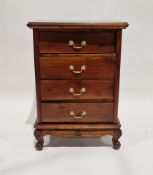 Reproduction mahogany chest of drawers having four long drawers, each with brass handles, raised