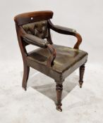 A 19th century oak arm chair with leatherette upholstered back, seat and arm rests, with button