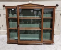 A contemporary glazed wall hanging display cabinet, the single door opening to reveal two fitted