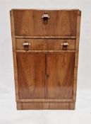 An Art Deco walnut veneer cocktail cabinet, the hinged top opening to reveal a mirrored storage area
