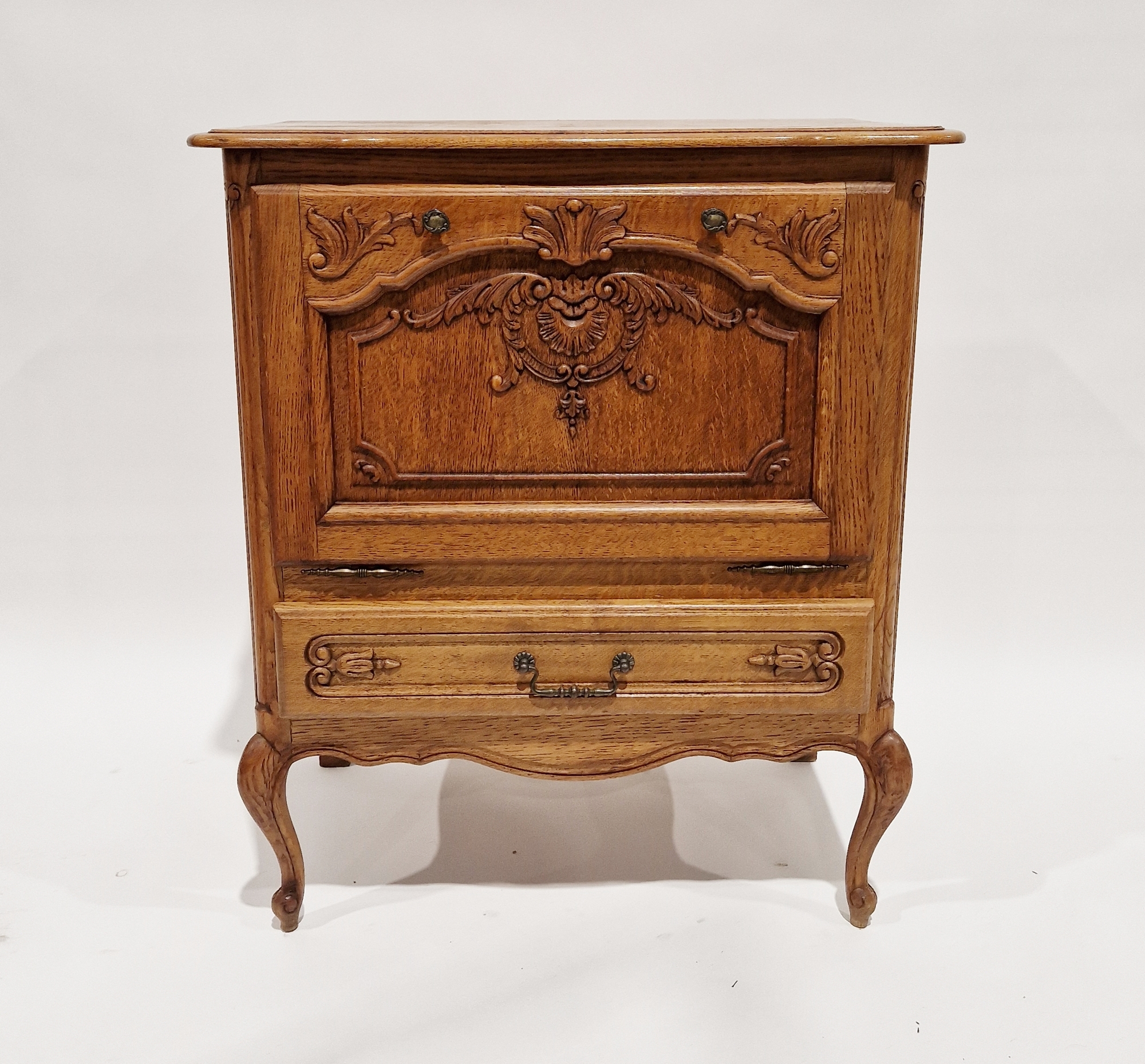 Contemporary oak storage cupboard, the fall front opening to reveal a storage compartment with
