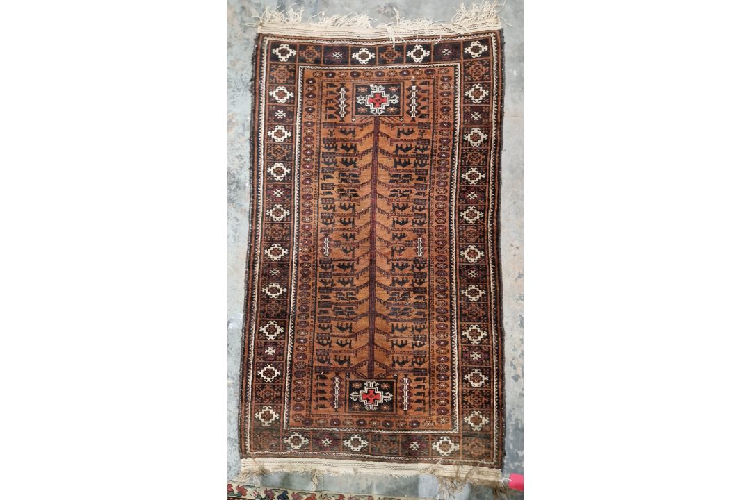 Baluchi brown ground rug, the central panel with tree of life style decoration containing stylised