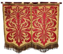 A 18th century Spanish armorial silk wall hanging embroidered with red silk cartouches,
