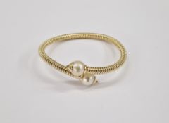 18K and pearl bangle having two large pearls to the ends of the reeded bangle, 21.8g total including