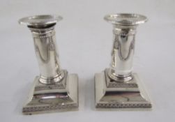 Late Victorian silver pair of squat candlesticks, with wreath and beaded decoration, square bases,
