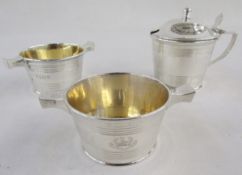 George V silver engraved armorial mustard pot and two salt cellars, each of cylindrical form with