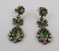 Pair emerald and diamond drop earrings, each in the form of flowerhead diamond cluster above