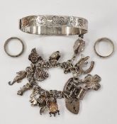 Silver bangle, partly engraved, a silver charm bracelet with numerous charms, 75g total and two