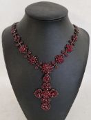 Victorian gilt metal, garnet necklace with cross pendant, the necklace of graduated flowerheads