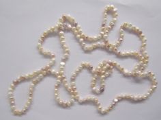 Two long strings of pink, cream and other coloured cultured pearls, a string of coloured cultured