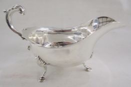 A George V silver sauceboat in the Georgian style, with acanthus scroll handle, shell cast terminals