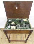 An oak canteen table on four barleytwist supports with stretchers, containing silver plated flatware