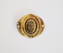 Gold coloured metal garnet and small diamond set brooch, oval medallion shape.