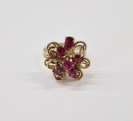 Gold coloured metal ruby and diamond ring, stylised flowerhead set with rubies and small diamonds