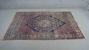 A Persian Hamadan, the central midnight lozenge medallion on a burgundy ground within stylised