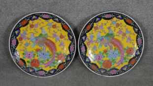 A pair of 20th century Chinese Famille Rose chargers with pheasant among flowers design on yellow