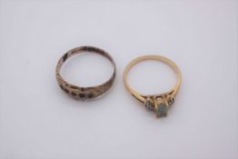 A 14 carat yellow gold flanked solitaire ring set with an oval aquamarine to centre flanked each