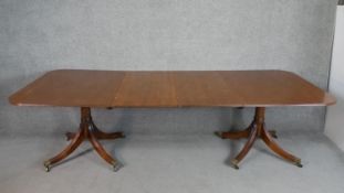 A Regency style mahogany D-end extending dining table with two additional leaves on quatraform bases