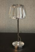 A table lamp with a prismatic glass shade, on a tubular chromed stem with a circular base. H.37